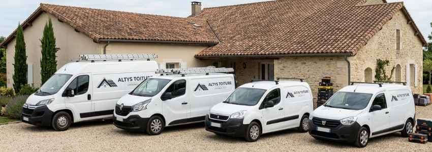 Les fourgons logotés Altys Toiture Langon alignés devant une maison de Langon en tuile canal